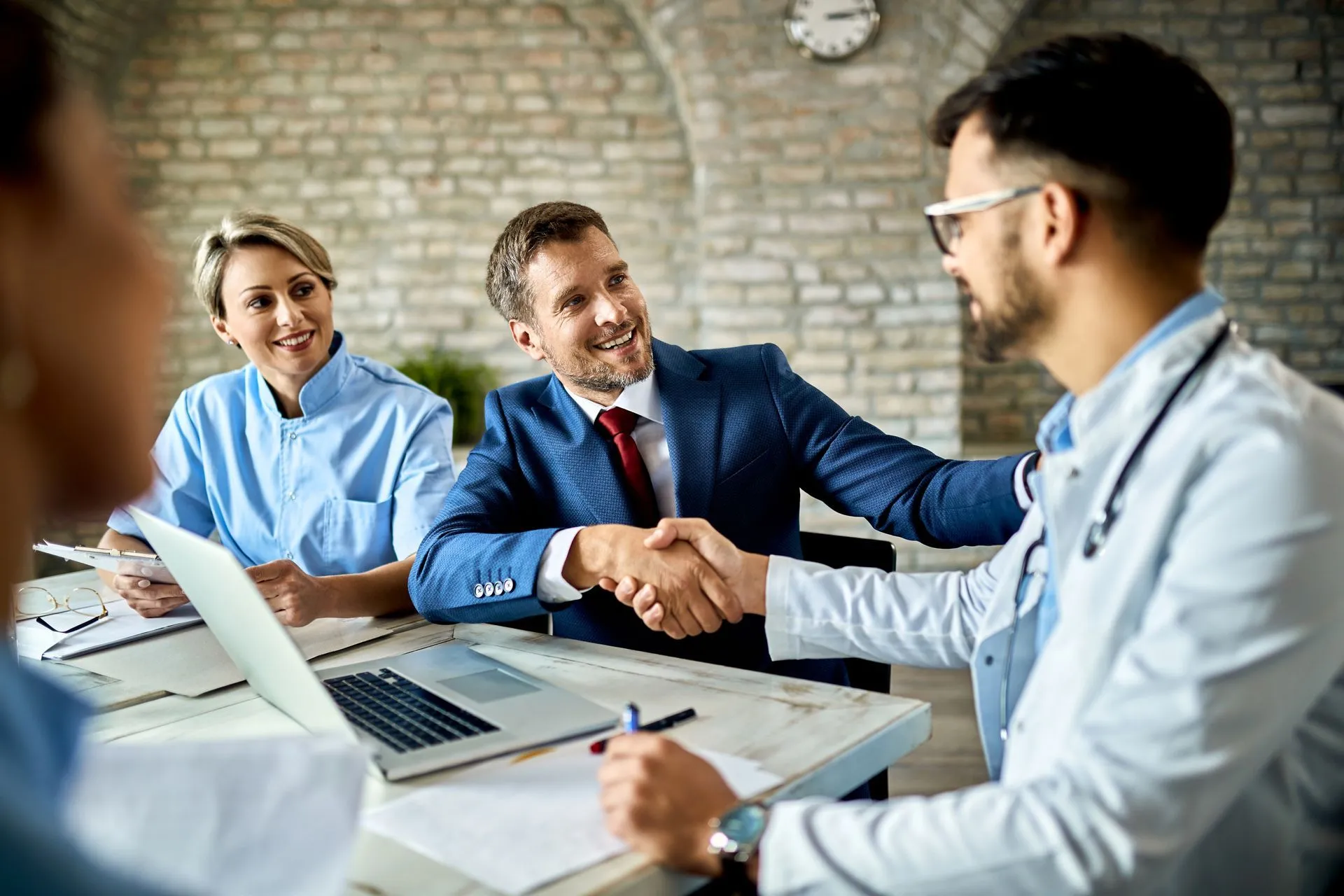 Businessman shaking hands with a doctor at a meeting.